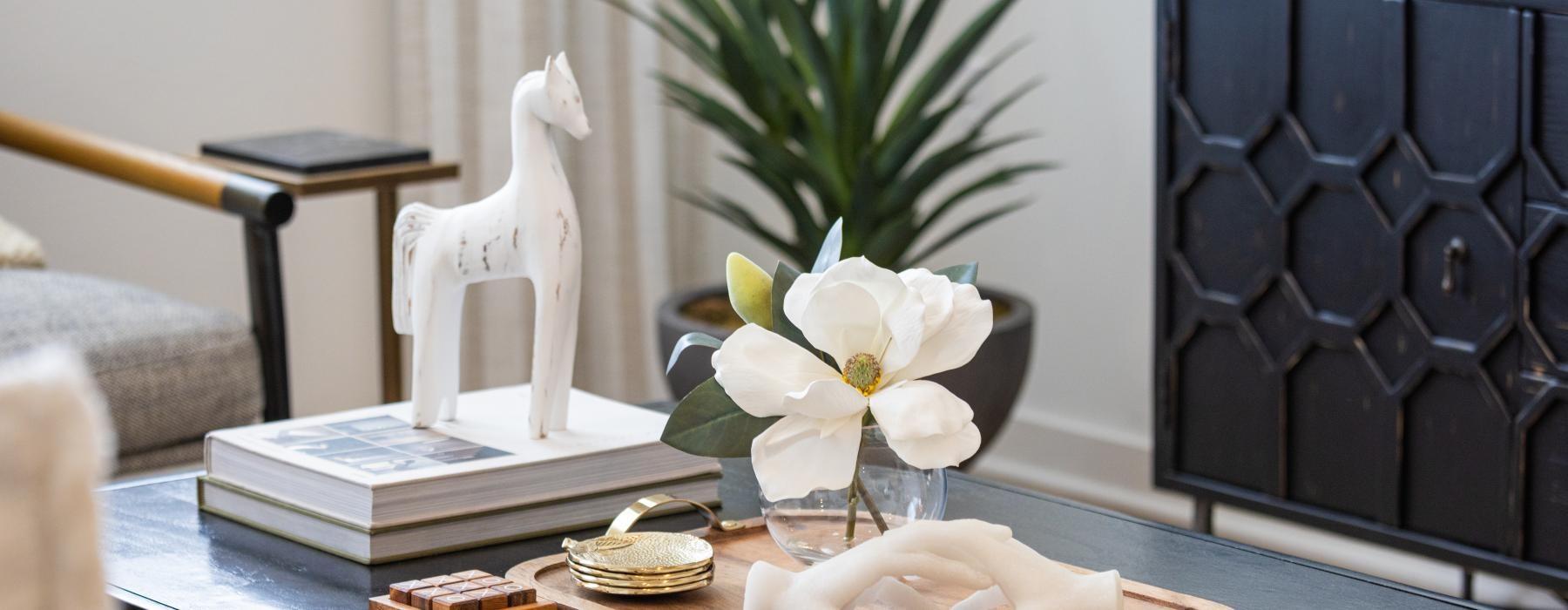 a table with a vase of flowers and a statue of a dog
