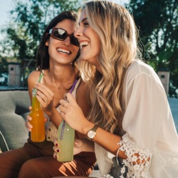 two women sitting near a pool